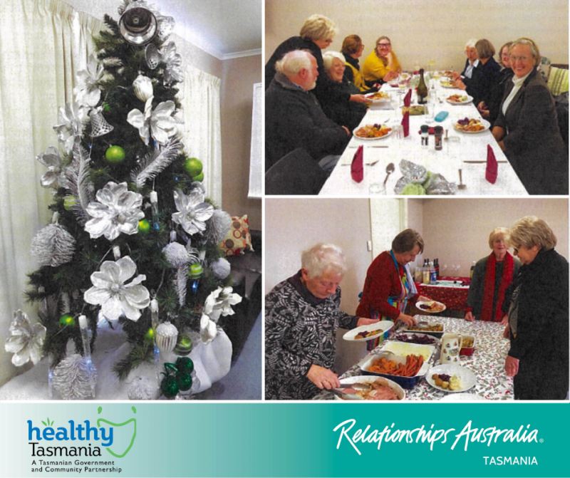 Older community members enjoying a Christmas meal with a large green and silver Christmas tree.