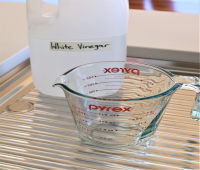 Bottle of white vinegar and measuring jug